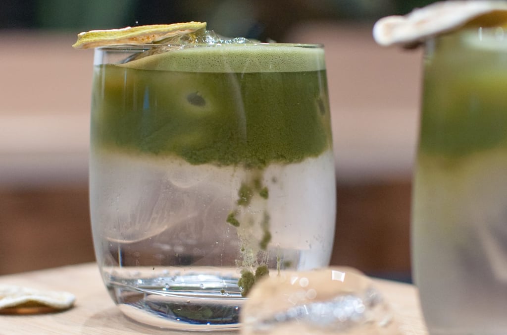 Detail sklenice s matcha latte s vrstvou zelené matchy usazující se do mléka